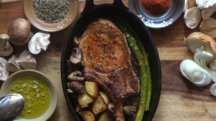 Fried Pork Chop with Asparagus, Potatoes, and Mushroom, served in a Cast Iron Skillet.