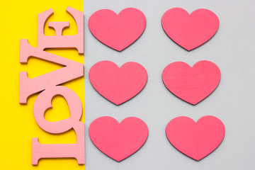 Wooden hearts on a multi-colored background, top view