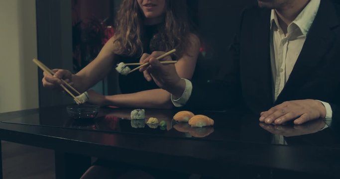 Man and woman eating sushi in the city