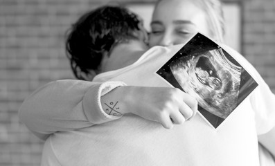 White couple with baby ultrasound photo