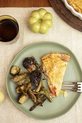 Slice of Ham and Cheese Tart Pie served with brussel sprouts and asparagus in a dinner setting
