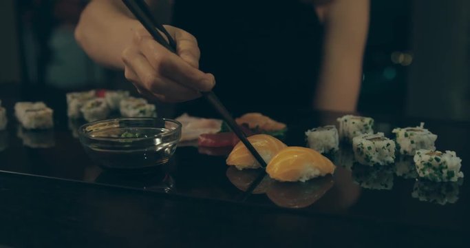 Elegant woman eating sushi in the city