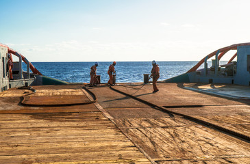 Anchor-handling Tug Supply AHTS vessel crew preparing vessel for static tow tanker lifting. Ocean...