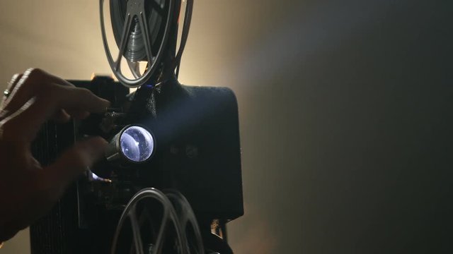 Close up of a hand focusing a vintage film projector