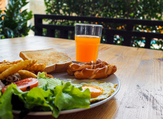 English breakfast with fried eggs, sausages,toasts and fresh salad