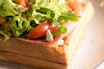 Homemade Belgian Waffle with salad Iceberg, tomatoes and ham