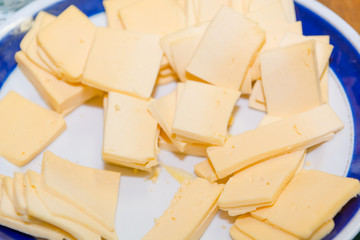 Sliced cheese on a plate. Cheese sliced. Cheese close-up.