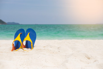 Beach sandals on the sandy sea coast, summer concept holiday and vacation concept. Tropical sea