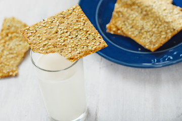 Fitness cookies with chia seeds, flax and pumpkin on white wooden background with glass milk, healthy food