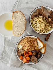 Healthy food concept. Healthy porridge with stewed vegetables and turkey on white wooden table close up, top view