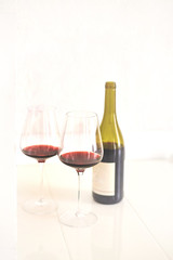 Red wine glasses and bottle on white background