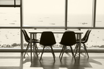 Modern studio with empty desk and glass facade with ocean view.  Nobody.  Copy space.