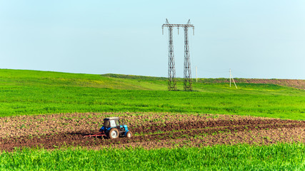 Tractor plows farm fields in the spring