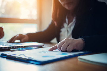 Businesswoman analyzes market data on charts.