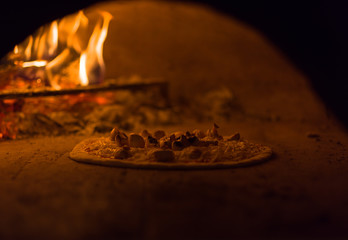chef putting delicious pizza to brick wood oven