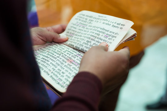 Hindu Priest Reading Sacred Texts at Wedding