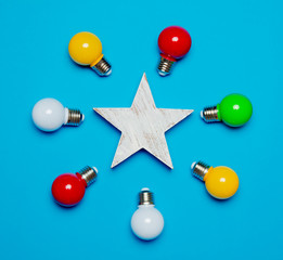 colored bulbs and wooden star on blue background