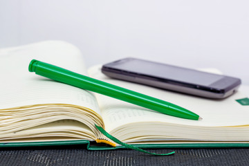 Notepad, pen and phone - means of recording information during  press conference or business planning_