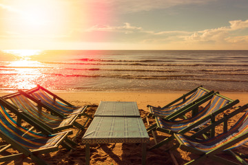 beach chair and table on the beach with sunset
