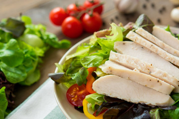 Salad toppped with skinless chicken breast