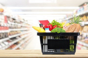 Shopping basket full of food and groceries on the table in supermarket