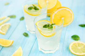 Sweet and sour lemonade juice with ice cubes in the glasses - obrazy, fototapety, plakaty