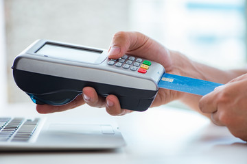 Man processing credit card transaction with POS terminal