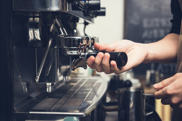 Barista making coffee with machine in cafe