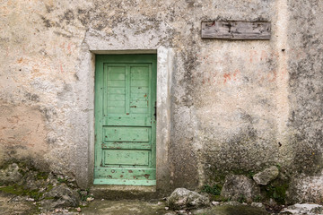 Very old weathered green door made of wood
