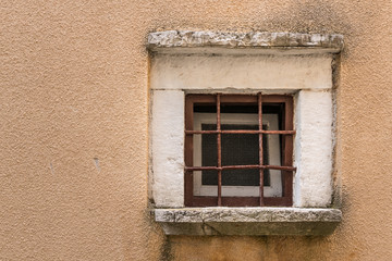 Fototapeta na wymiar Small window with grille gate in Croatia