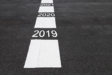 Number of 2019 to 2021 on asphalt road surface with marking lines, happy new year concept