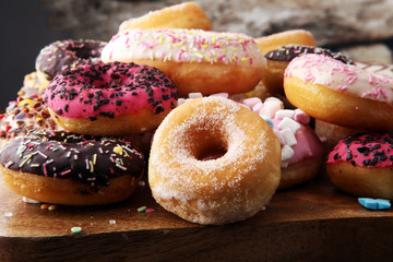 assorted donuts with chocolate frosted, pink glazed and sprinkles donuts.