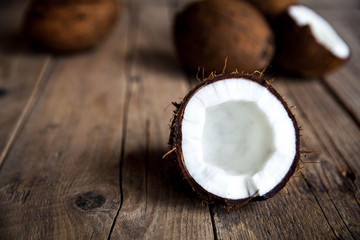 Obraz na płótnie Canvas Ripe half cut coconut on a wooden background. Ripe half cut coconut on a wooden background. Coconut cream and oil.