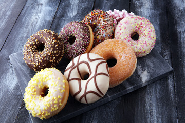 assorted donuts with chocolate frosted, pink glazed and sprinkles donuts.