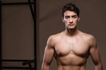 Ripped muscular man in gym doing sports
