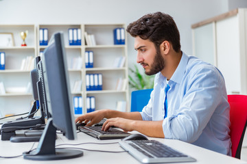 Fototapeta premium Businessman sitting in front of many screens