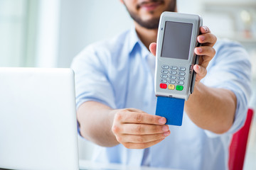 Man processing credit card transaction with POS terminal