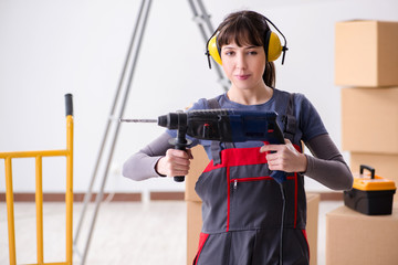 Woman contractor with hand drill at construction site