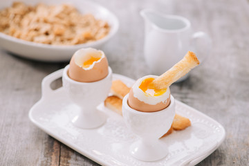 delicious breakfast with soft boiled eggs and crispy toasts, closeup