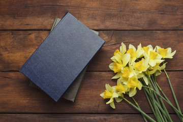 Spring flower Narcissus, Books on a dark wooden background