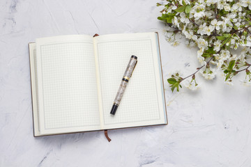 Diary, Cherry twig with flowers on a stone background. Flat lay, top view