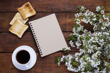Cup with Black coffee, Toast, Notepad, Sprig with Colors on a dark wooden background