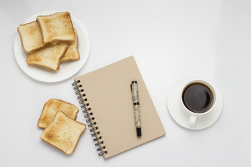 Obraz na płótnie Canvas White cup with black coffee, Toasts on a white plate, Notepad on a white background. Concept of a healthy spring breakfast