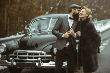 Travel and business trip or hitch hiking. Retro collection car and auto repair by mechanic driver. Escort of girl by security. Couple in love on romantic date. Bearded man and sexy woman in fur coat.