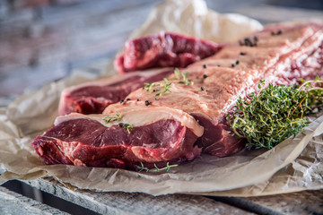 Raw rib eye beef steak with salt spices and herbs