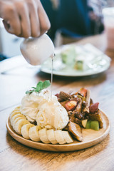 Honey Toast With ice cream and banana on wooden table in the cafe.