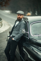 businessman in suit and cap at retro car. businessman on road.