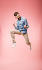 Fototapeta na wymiar Full length of a satisfied young man jumping