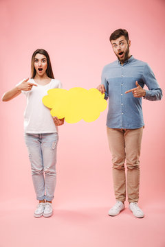 Full length portrait of an excited young couple pointing