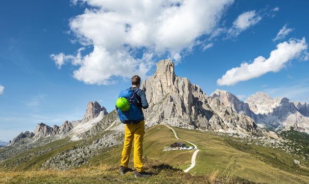 Hiker looking down to Passo Giau, at the back La Gusela, Averau and Tofane, Dolomites, South Tyrol, Trentino-Alto Adige, Italy, Europe